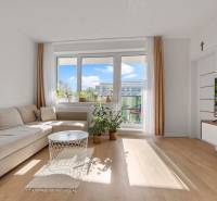 | Krásny a moderný 2-izbový byt | 51,50m² | - Obývacia izba v 2-izbovom byte s pohovkou a balkónovými dverami. Podlaha s dreveným dekorom.