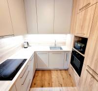 Posledný investičný krásny 2-izbový byt | 62 m² | RÍNOK RAČA - Kuchyňa s podlahou s dreveným dekorom v 2-izbovom byte, so zabudovanými spotrebičmi.