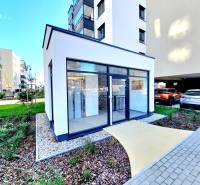 Posledný investičný krásny 2-izbový byt | 62 m² | RÍNOK RAČA - Chodník vedúci k presklenej budove, okolo sú upravené záhrady a parkovisko.