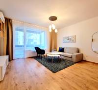 Posledný investičný krásny 2-izbový byt | 62 m² | RÍNOK RAČA - Obývacia izba s pohovkou a podlahou s dreveným dekorom v 2-izbovom byte.