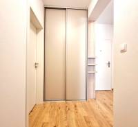 Posledný investičný krásny 2-izbový byt | 62 m² | RÍNOK RAČA - Chodba 2-izbového bytu s posuvnými dverami a podlahou s dreveným dekorom.