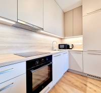 Posledný investičný krásny 2-izbový byt | 55 m² | RÍNOK RAČA - Kuchyňa v 2-izbovom byte s podlahou s dreveným dekorom a vstavanými spotrebičmi.