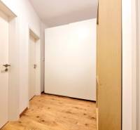 Posledný investičný krásny 2-izbový byt | 55 m² | RÍNOK RAČA - Biela skriňa a drevená podlaha na chodbe v 2-izbovom byte.