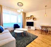 Posledný investičný krásny 2-izbový byt | 55 m² | RÍNOK RAČA - Obývacia izba s pohovkou, televízorom a jedálenským stolom, podlaha s dreveným dekorom.