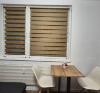 Prenájom 1- izbový byt  - Jedálenský kút s dreveným stolíkom a dvoma bielymi stoličkami v 1-izbovom byte.