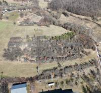 Predaj , slnečné pozemky nad Krupinou , Tepličky - Letecký pohľad na rozľahlé pozemky na bývanie v Krupine, s lesmi a poľami.