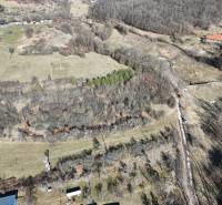 Predaj , slnečné pozemky nad Krupinou , Tepličky - Letecký pohľad na pozemky pre bývanie v Krupine, obklopené prírodou a stromami.