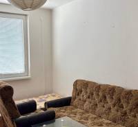 Predaj garsónky – Tlmače, Lipník- ihneď voľná (MK-3) - Garsónka s pohovkou, kreslom a stolíkom, podlaha s dreveným dekorom, papierové svietidlo.