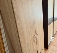 Predaj garsónky – Tlmače, Lipník- ihneď voľná (MK-3) - Skriňa v garsónke s podlahou s dreveným dekorom a posuvnými dverami.