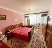 PREŠOV-3 IZBOVÝ BYT,LODŽIA,67m2,SÍDLISKO III.,MATICE SLOVENSKEJ - Spálňa v 3-izbovom byte s červenými doplnkami a podlahou s dreveným dekorom.