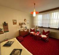 PREŠOV-3 IZBOVÝ BYT,LODŽIA,67m2,SÍDLISKO III.,MATICE SLOVENSKEJ - Izba v 3-izbovom byte so starším nábytkom, červeným kobercom a dekoráciami.