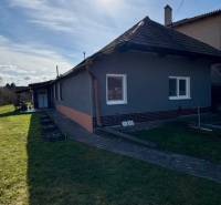 Útulný rodinný dom v tichej lokalite Mýtnych Ludán (MK-4) - Rodinný dom v Mýtnych Ludanoch, obklopený záhradou, s modrou oblohou a slnkom.