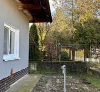 Útulný rodinný dom v tichej lokalite Mýtnych Ludán (MK-4) - Rodinný dom v Mýtnych Ludanoch s bočnou záhradkou a trávnikom, obklopený plotom.