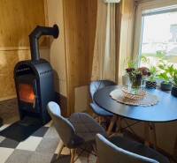 Útulný rodinný dom v tichej lokalite Mýtnych Ludán (MK-4) - Krb v obývačke rodinného domu s okrúhlym stolom a dvoma stoličkami.