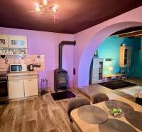 Útulný rodinný dom v tichej lokalite Mýtnych Ludán (MK-4) - Kuchyňa a obývačka v rodinnom dome s podlahou s dreveným dekorom a krbom.