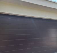 Luxusný rodinný dom s bazénom a dvojgarážou v Komárne - Garážové dvere pri rodinnom dome v Komárne, obklopené zeleňou.