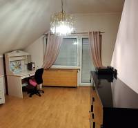 Luxusný rodinný dom s bazénom a dvojgarážou v Komárne - Izba s podlahou s dreveným dekorom, nábytkom a lustrom v rodinnom dome.