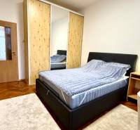 REZERVOVANÉ Na prenájom 3 izbový byt, 73 m2, Bratislava, Zochova - Spálňa v 3-izbovom byte s posteľou, šatníkom a podlahou s dreveným dekorom.