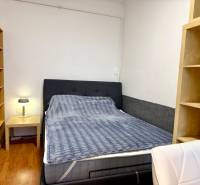 REZERVOVANÉ Na prenájom 3 izbový byt, 73 m2, Bratislava, Zochova - Spálňa s posteľou, stolíkom, lampou a podlahou s dreveným dekorom v 3-izbovom byte.