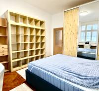 REZERVOVANÉ Na prenájom 3 izbový byt, 73 m2, Bratislava, Zochova - Spálňa v 3-izbovom byte s podlahou s dreveným dekorom, úložnými priestormi a zrkadlom.