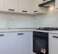 KRÁSNY NOVOZREKONŠTRUOVANÝ 3IB, SNP,POVAŽSKÁ BYSTRICA - Kuchyňa v 3-izbovom byte so sporákom a bielymi skrinkami.