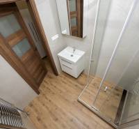 KRÁSNY NOVOZREKONŠTRUOVANÝ 3IB, SNP,POVAŽSKÁ BYSTRICA - Kúpeľňa s vaňou, umývadlom a podlahou s dreveným dekorom v 3-izbovom byte.