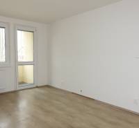 PRENÁJOM –  1 izba (príp. 2 izby) v 3-izb. byte, Gwerkovej ul., BA V - Izba s podlahou s dreveným dekorom v 3-izbovom byte, stôl a stolička.