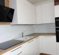 PRENÁJOM – 1 izba (príp. 2 izby) v 3-izb. byte, Gwerkovej ul., BA V - Kuchyňa s bielymi skrinkami a spotrebičmi, doplnená podlahou s dreveným dekorom v 3-izbovom byte.