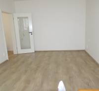 PRENÁJOM –  1 izba (príp. 2 izby) v 3-izb. byte, Gwerkovej ul., BA V - Izba v 3-izbovom byte s bielymi stenami a podlahou s dreveným dekorom.