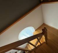 PREDAJ : RODINNÝ DOM, KOMÁRNO - Schodisko s dreveným dekorom v rodinnom dome so schodiskovým zábradlím a kruhovým oknom.