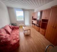 TOP 3 izbový byt v Moravskom Lieskovom s garážou a predzáhradkou - Izba v 3-izbovom byte s pohovkou, skriňami a stolíkom na svetlej podlahe.