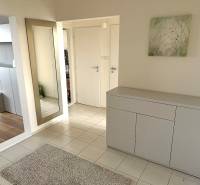 Prenájom 3 izbový byt, Švabinského ulica, Bratislava V. Petržalka - Predsieň v 3-izbovom byte s bielym nábytkom, zrkadlom a podlahou s dreveným dekorom.