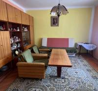 RD Drahovce ZĽAVA !!! - Obývačka v rodinnom dome s retro nábytkom, zelenými kreslami a veľkým kobercom.