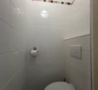 -PREDAJ - 1 IZBOVÝ BYT 40m2- TRENČIANSKA - RUŽINOV - Kúpeľňa v 1-izbovom byte s bielymi dlaždicami a stenou s dekoratívnym pásikom.