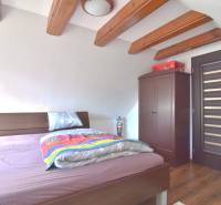 LIMBACH, 176 m2 –  kompletne zrekonštruovaný 5-i rodinný dom - Spálňa v podkroví s drevenými trámami, posteľou a skriňou, dom na ulici Limbach.