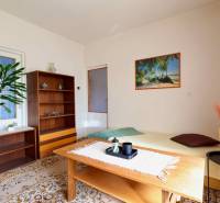 RD v jednej z najžiadanejších lokalít Michaloviec – pod Hrádkom - Obývacia izba v rodinnom dome s kobercovou podlahou, dreveným nábytkom a obrazom pláže.