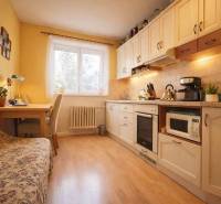 REZERVONY - 2 izbový tehlový byt na Novej Dubnici, 60  - Kuchyňa v 2-izbovom byte s dreveným dekorom podlahy, svetlým nábytkom a jedálenským kútom.