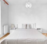 Slnečný 2i byt, pivnica, internet v cene, Nivy, Niťová ul. - Spálňa v 2-izbovom byte s posteľou, nočnými stolíkmi a podlahou s dreveným dekorom.