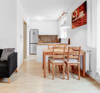 Slnečný 2i byt, pivnica, internet v cene, Nivy, Niťová ul. - Obývacia izba s kuchyňou v 2-izbovom byte a podlahou s dreveným dekorom.