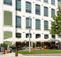 Slnečný 2i byt, pivnica, internet v cene, Nivy, Niťová ul. - Biela budova so zelenými okenicami, terasou a stromami v Bratislave na Svätoplukovej ulici.