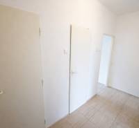 Rezervovaný/ Na predaj 2-izb. byt s loggiou, Senica, Paláriková ul. - Chodba v 2-izbovom byte s bielymi dverami a dlažbou.