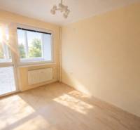 Rezervovaný/ Na predaj 2-izb. byt s loggiou, Senica, Paláriková ul. - Izba s veľkým oknom a podlahou s dreveným dekorom v 2-izbovom byte.