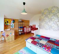 3D, Predaj novostavba, celoročne obývateľná chata, Stupava, Ovocinár - Detská izba v chate s dreveným obkladom, farebnou prikrývkou a kvetinovou tapetou.