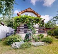 3D, Predaj novostavba, celoročne obývateľná chata, Stupava, Ovocinár - Chata v Stupave ovocinár, obklopená zeleňou, kvetmi a záhradným chodníkom.