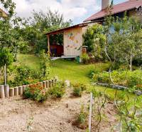 3D, Predaj novostavba, celoročne obývateľná chata, Stupava, Ovocinár   - Záhrada pri chate v Stupave, obklopená kvetmi a ovocnými stromami.