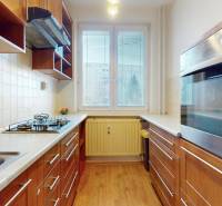 3-izbový byt s extrémne nízkymi nákladmi v Michalovciach - Kuchyňa v 3-izbovom byte s plynovým sporákom a podlahou s dreveným dekorom.