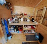Predáme záhradu so zrubovou chatou, Nitra - Dolné Krškany - Drevená kuchynka so spotrebičmi, poličkami a drezom v interiéri Záhrad.
