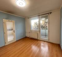 Predaj 3 izb. bytu s balkónom v NZ - Izba v 3-izbovom byte s podlahou s dreveným dekorom a balkónom.