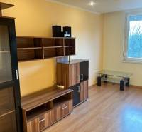 Predaj 3 izb. bytu s balkónom v NZ - Obývacia izba v 3-izbovom byte s nábytkom a podlahou s dreveným dekorom.