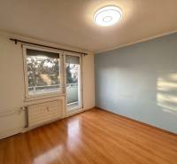 Predaj 3 izb. bytu s balkónom v NZ - Izba s podlahou s dreveným dekorom a balkónom v 3-izbovom byte.